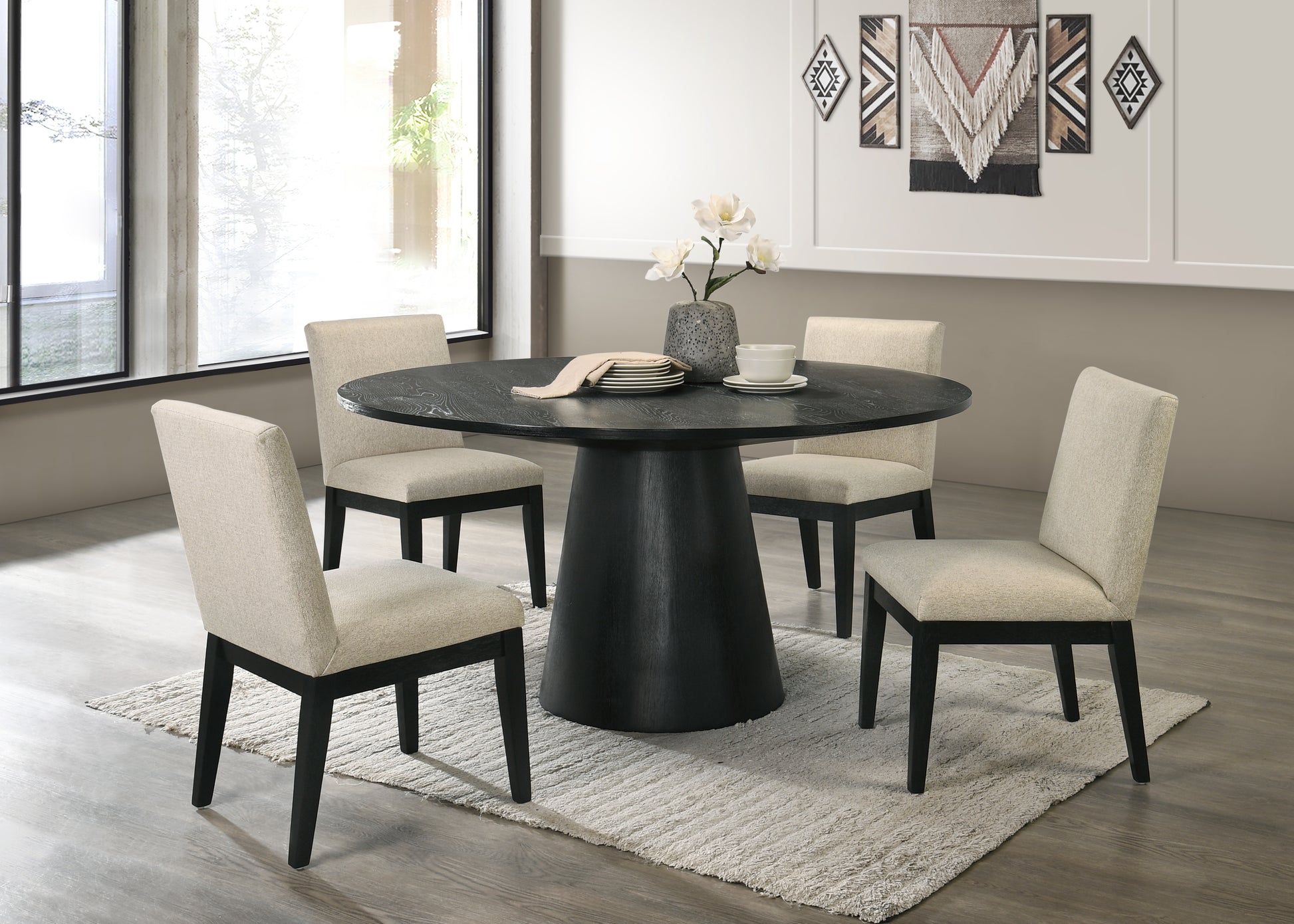 Black pedestal dining table with four upholstered chairs and minimalist decor