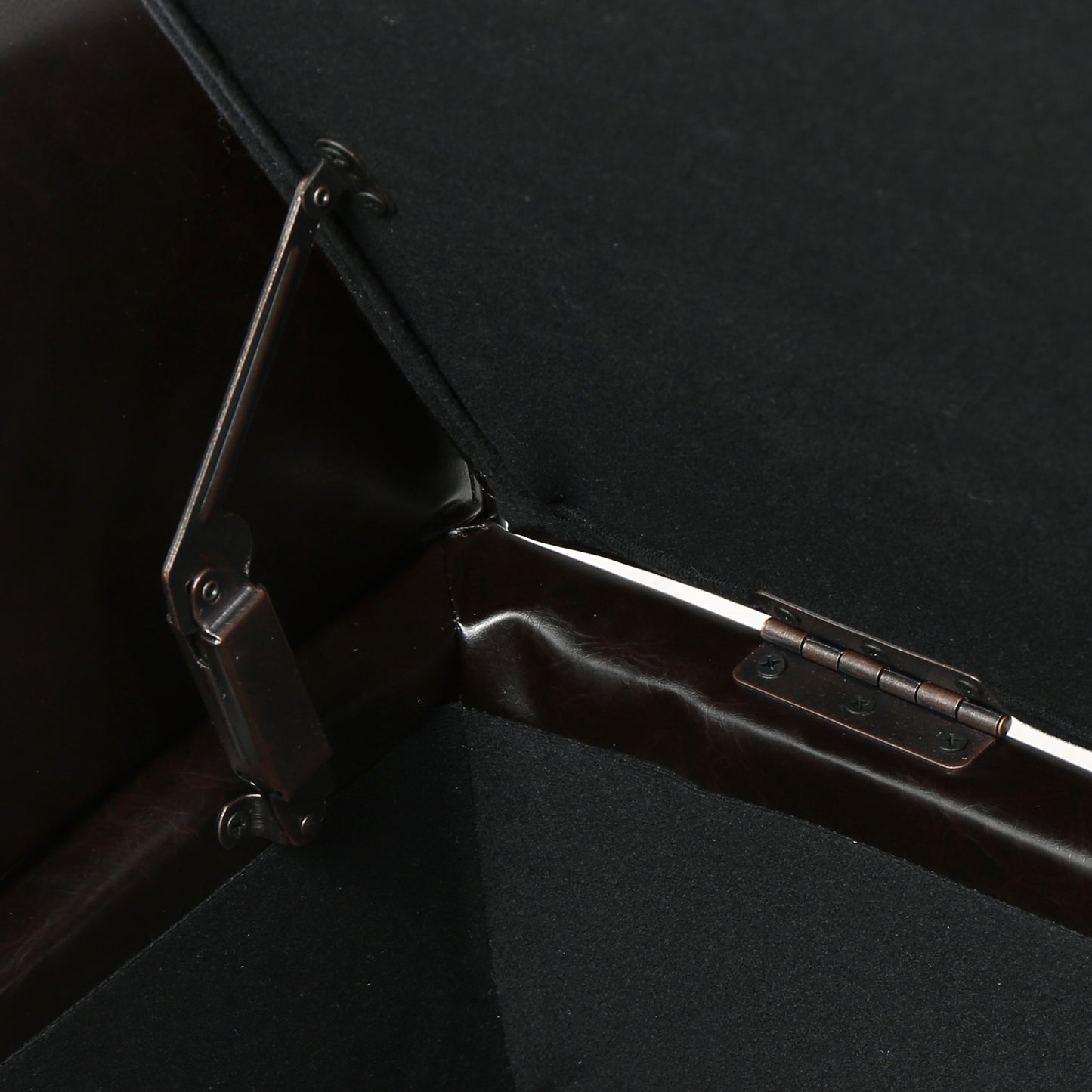 Dark brown leather storage ottoman hinge detail