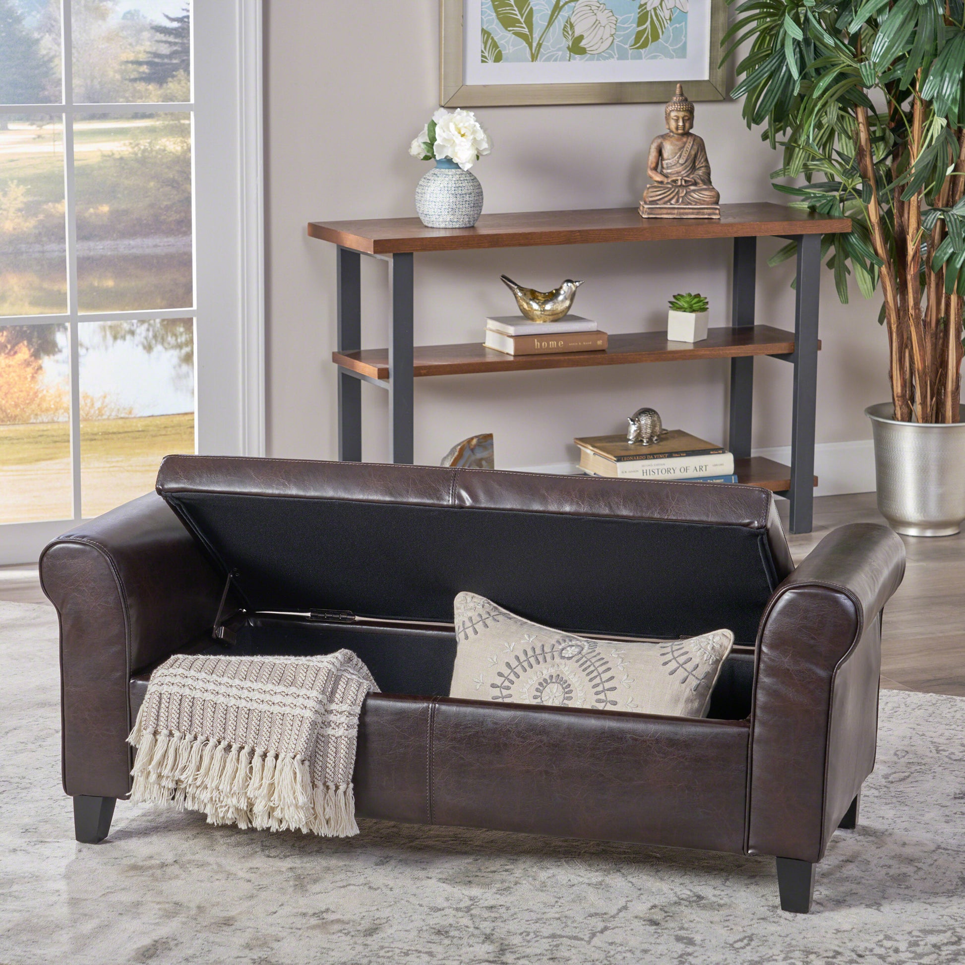 Dark brown faux leather storage ottoman bench with rolled arms and fringed throw
