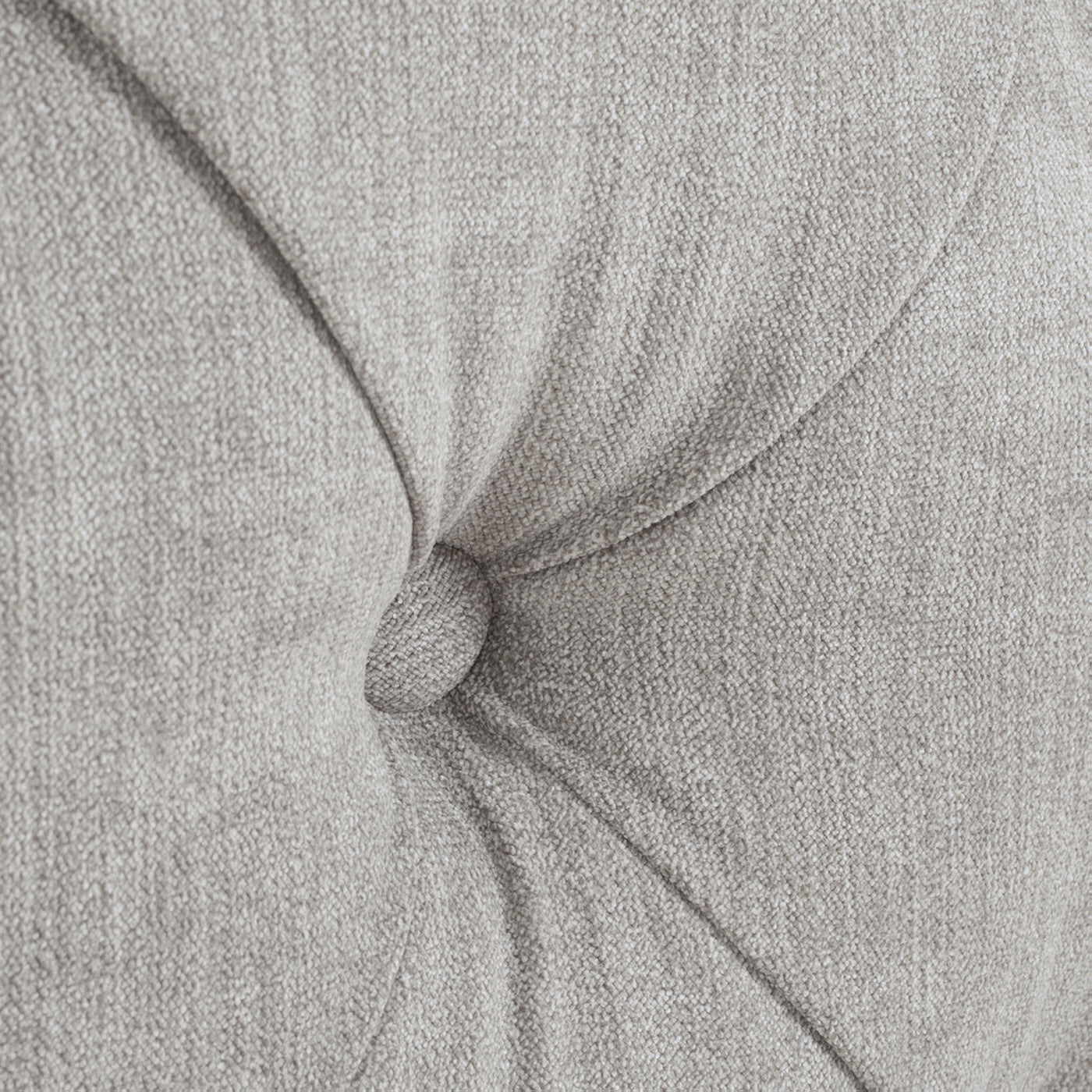 Closeup of light grey textured fabric with button tufting