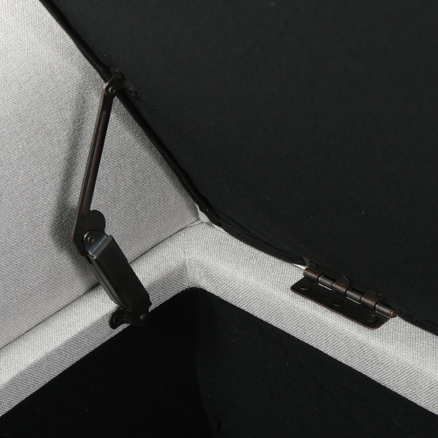 Closeup of a gray upholstered ottoman hinge mechanism