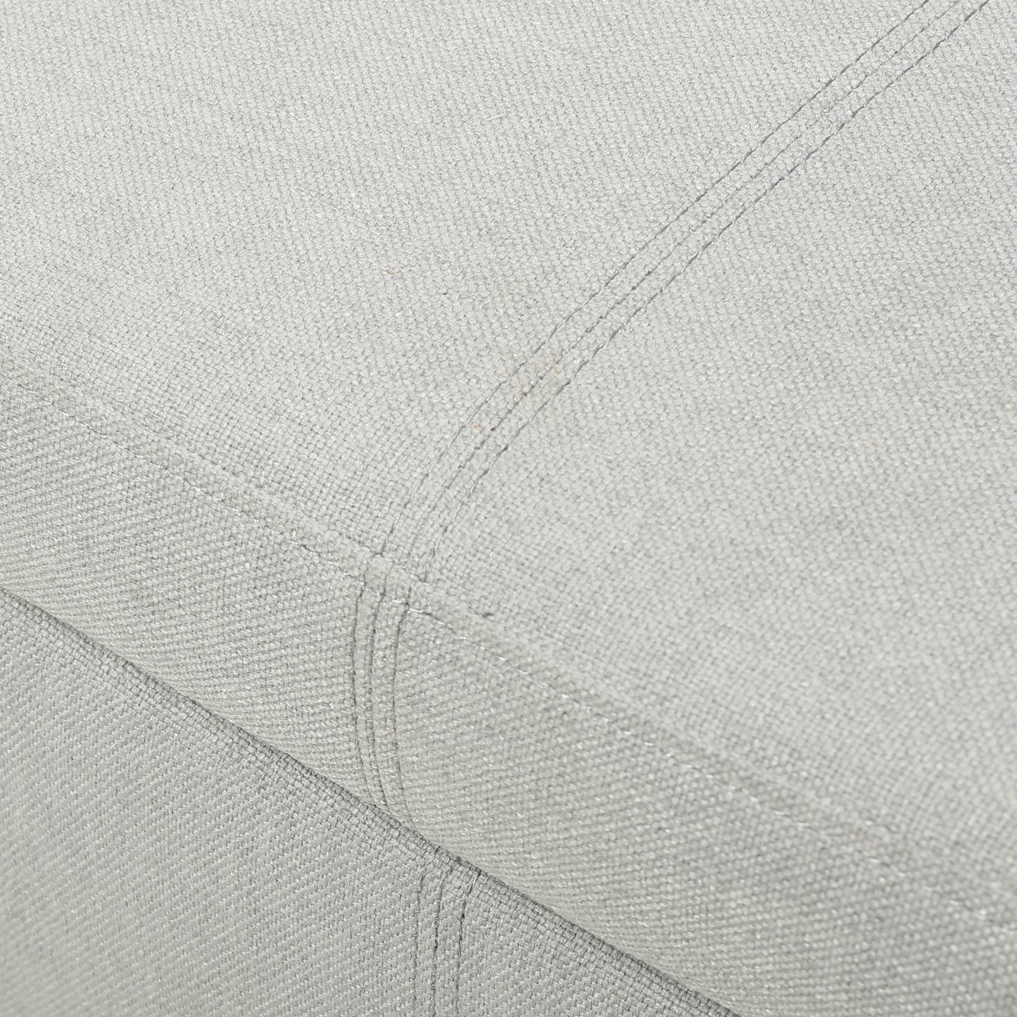 Closeup of light grey textured fabric with subtle stitching details