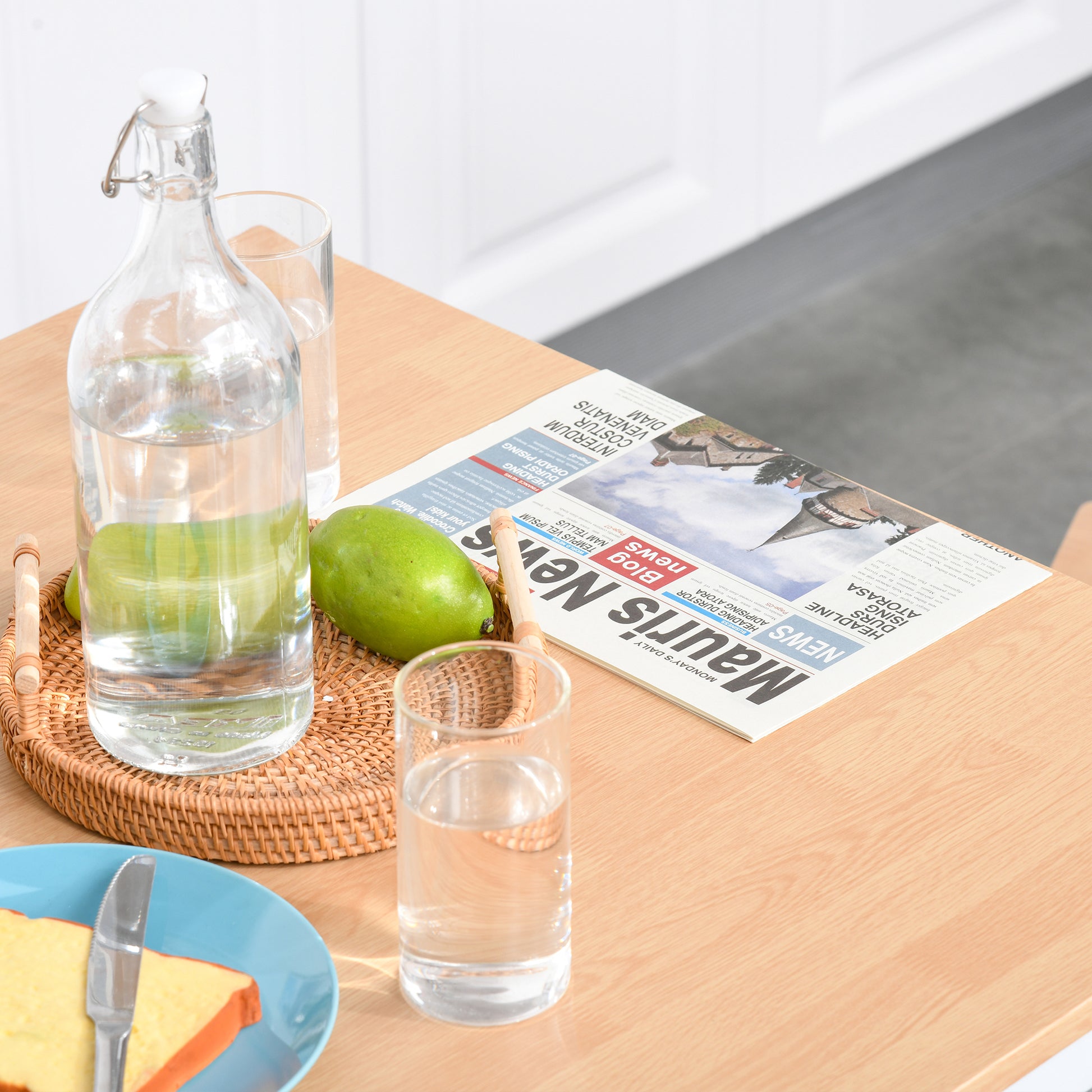 Glass bottle with water and limes on wicker tray