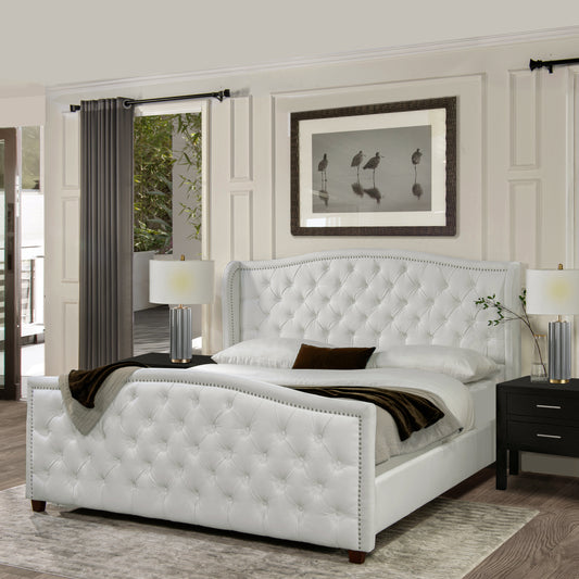 White tufted leather king bed with nailhead trim and curved wingback headboard
