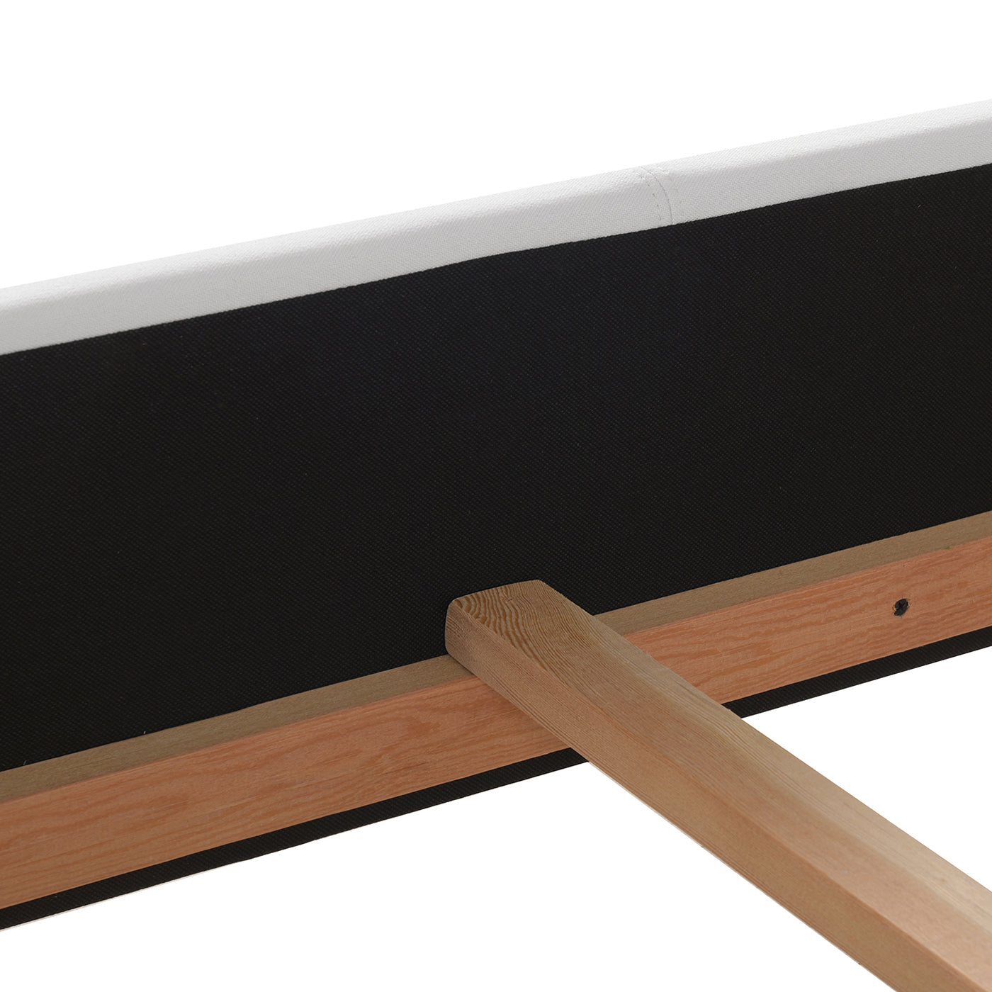 Upholstered bed frame detail with white fabric trim and wood support