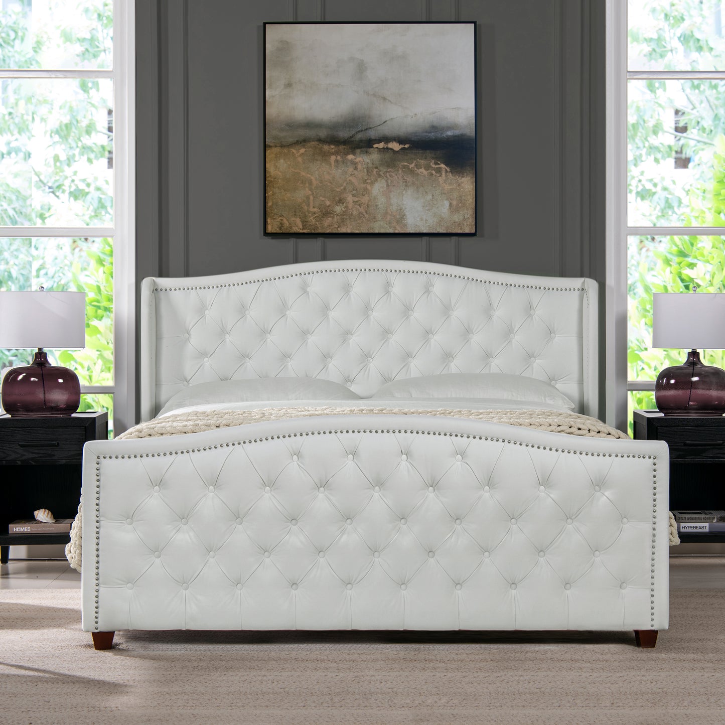 White tufted leather bed frame with nailhead trim and winged headboard