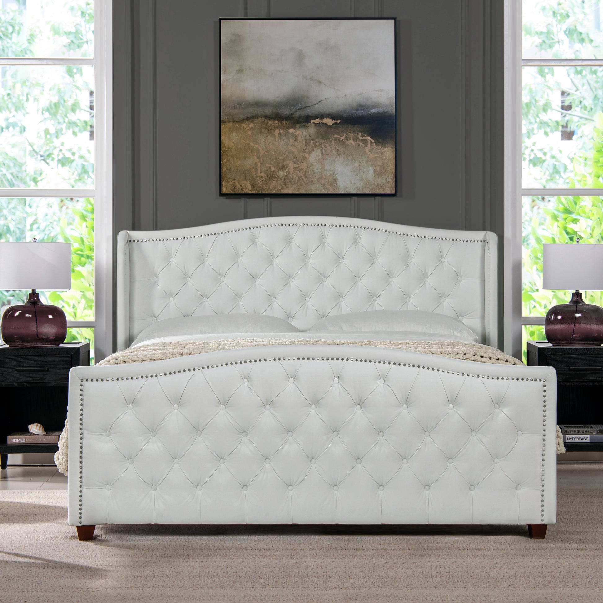 White tufted leather bed frame with nailhead trim and winged headboard