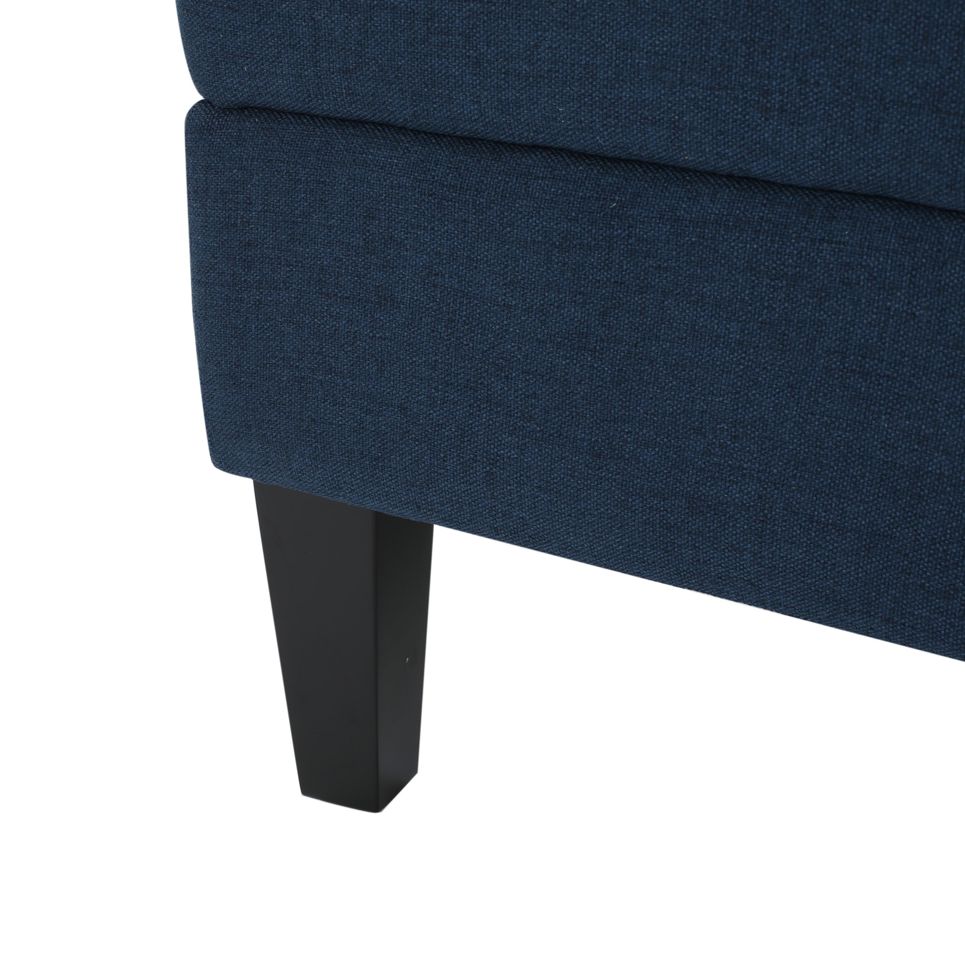 Closeup of navy blue textured fabric on a sofa armrest