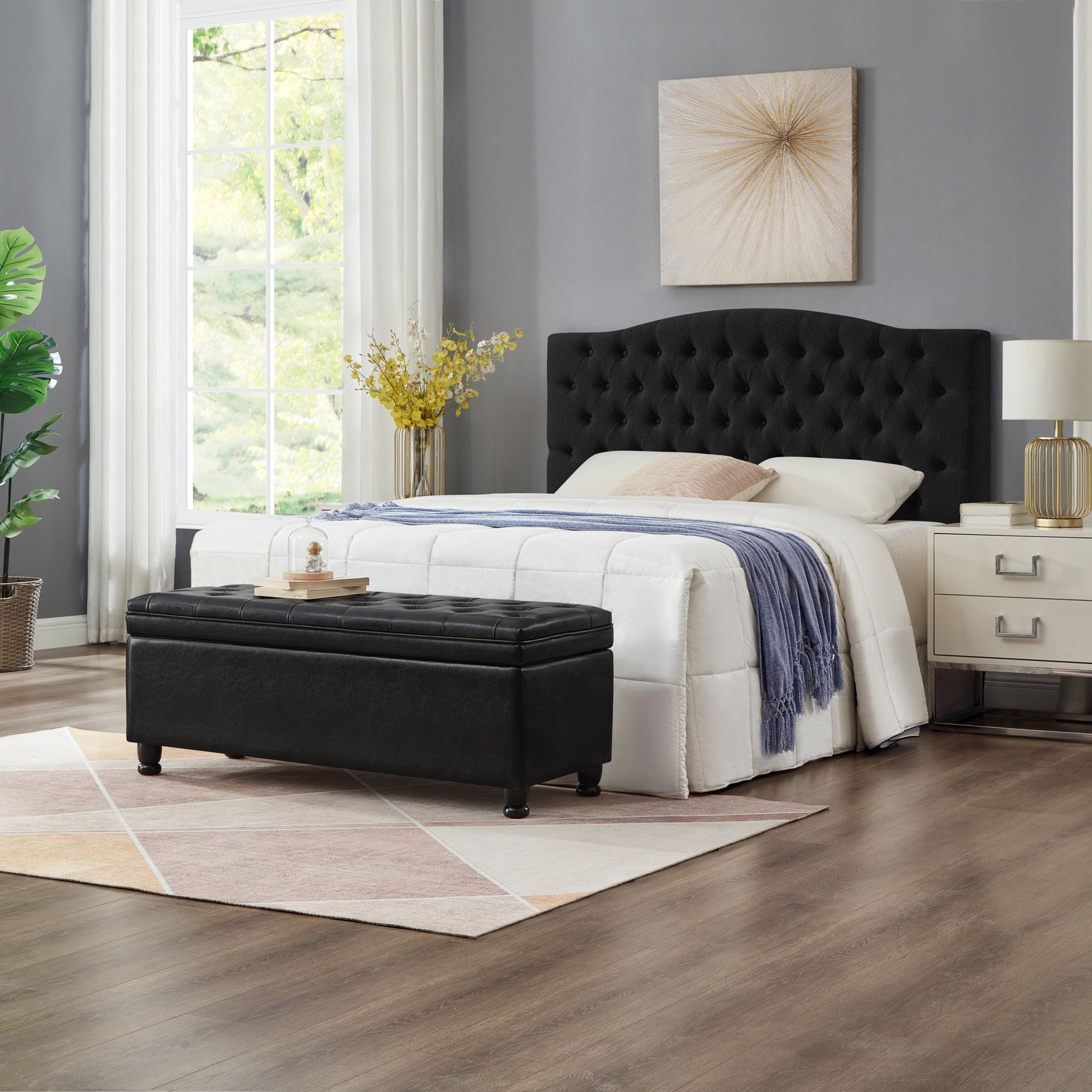 Black tufted storage ottoman with faux leather upholstery and dark wooden legs