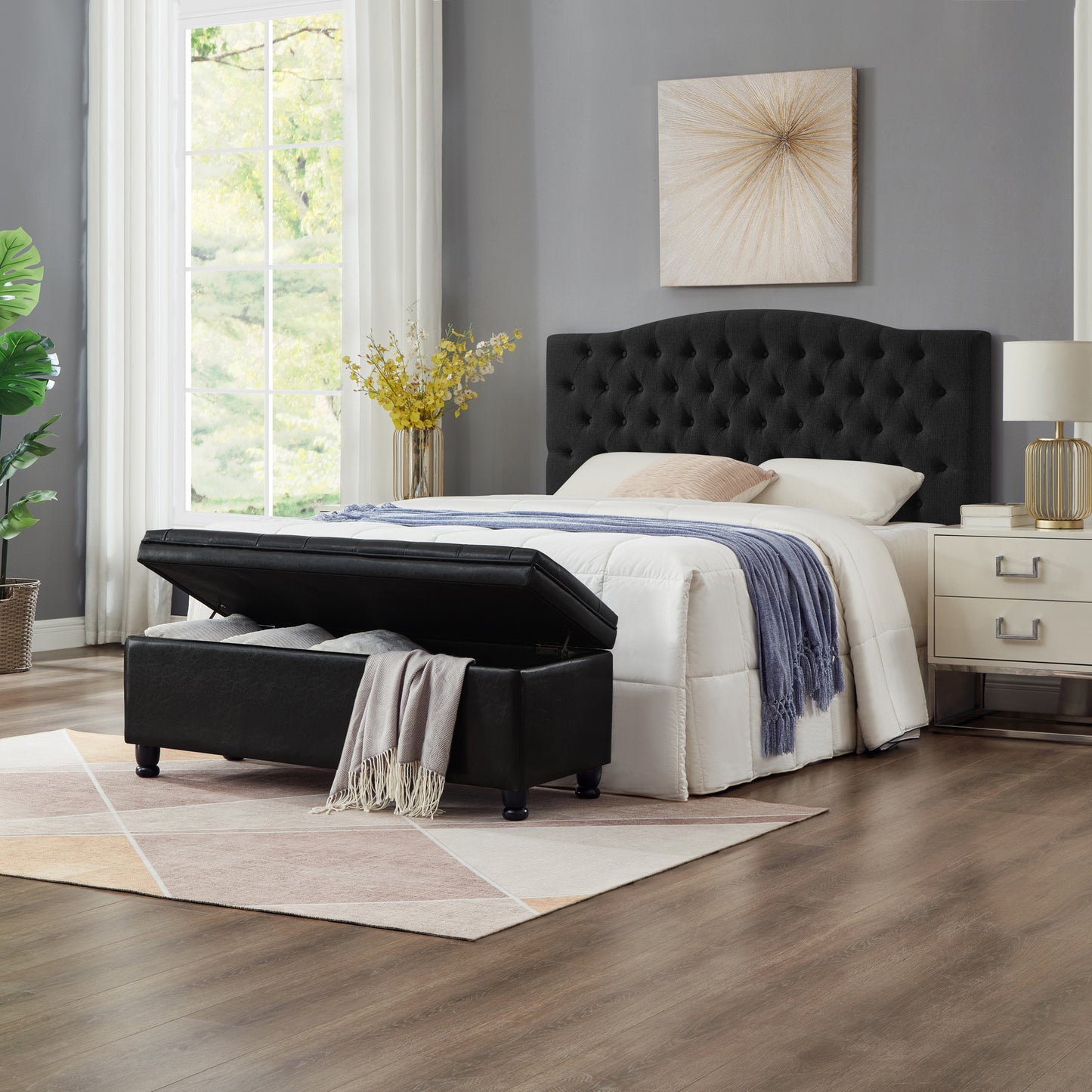 Black upholstered storage ottoman with tufted headboard and bedding