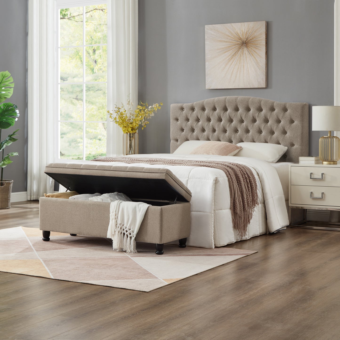 Tufted beige fabric ottoman storage bench open with blankets inside