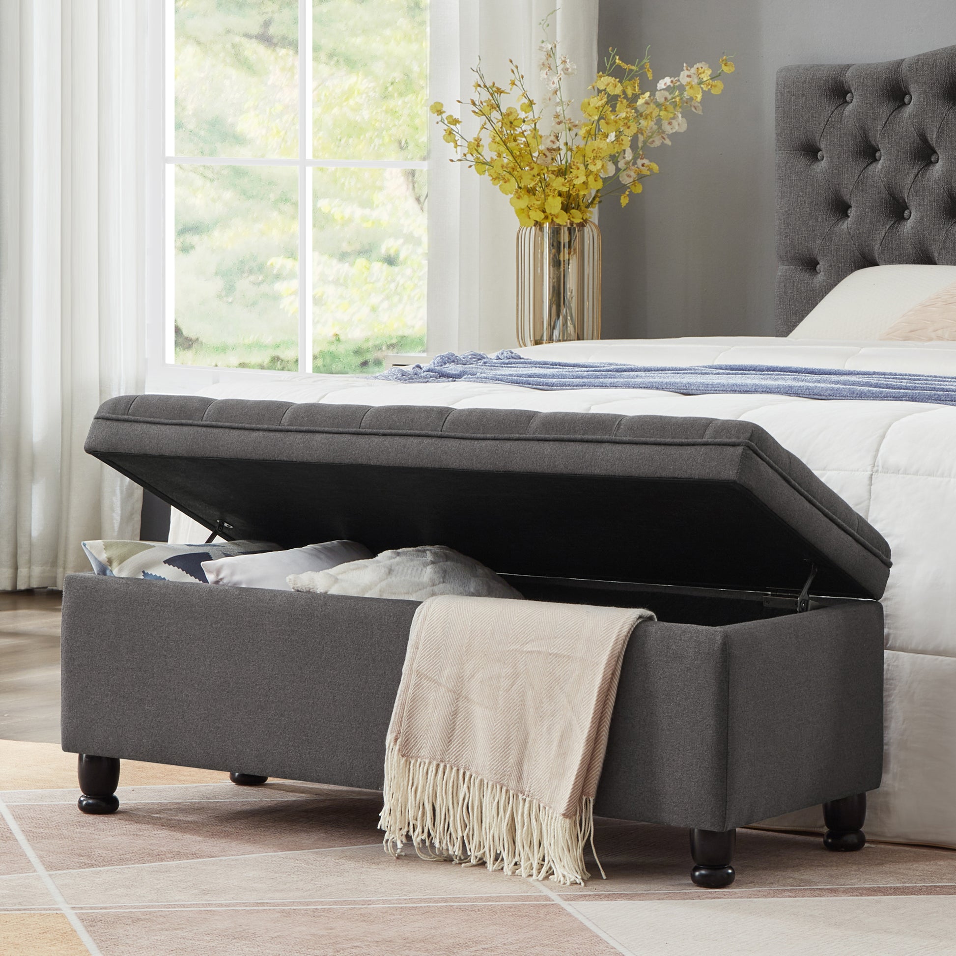 Dark gray upholstered storage bench with tufted lid perfect for bedroom storage solutions
