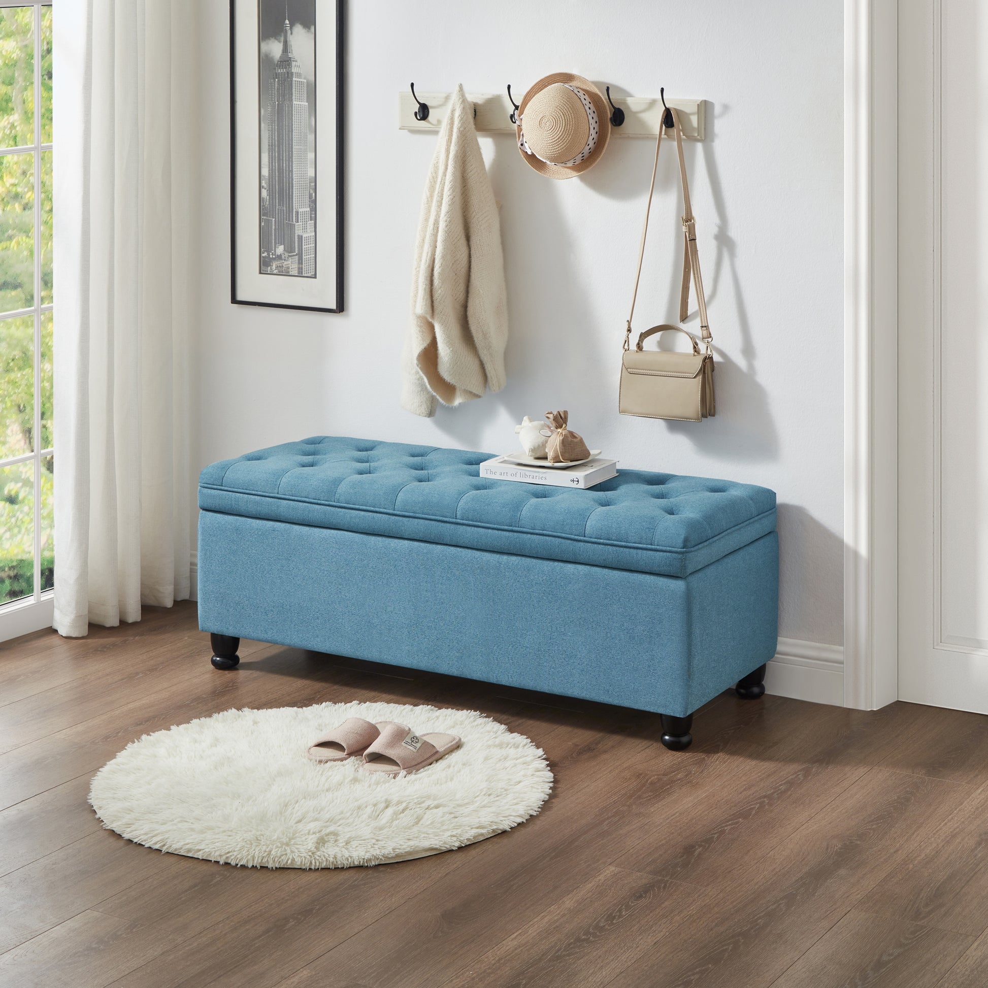Blue tufted storage ottoman with black legs
