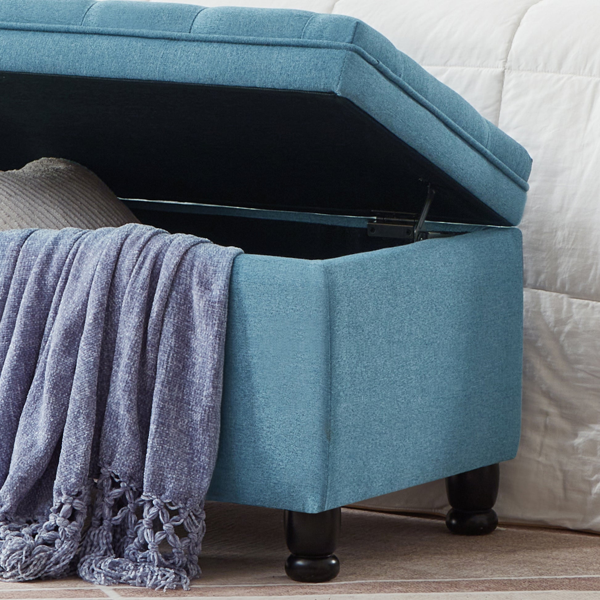 Blue fabric storage ottoman with tufted lid