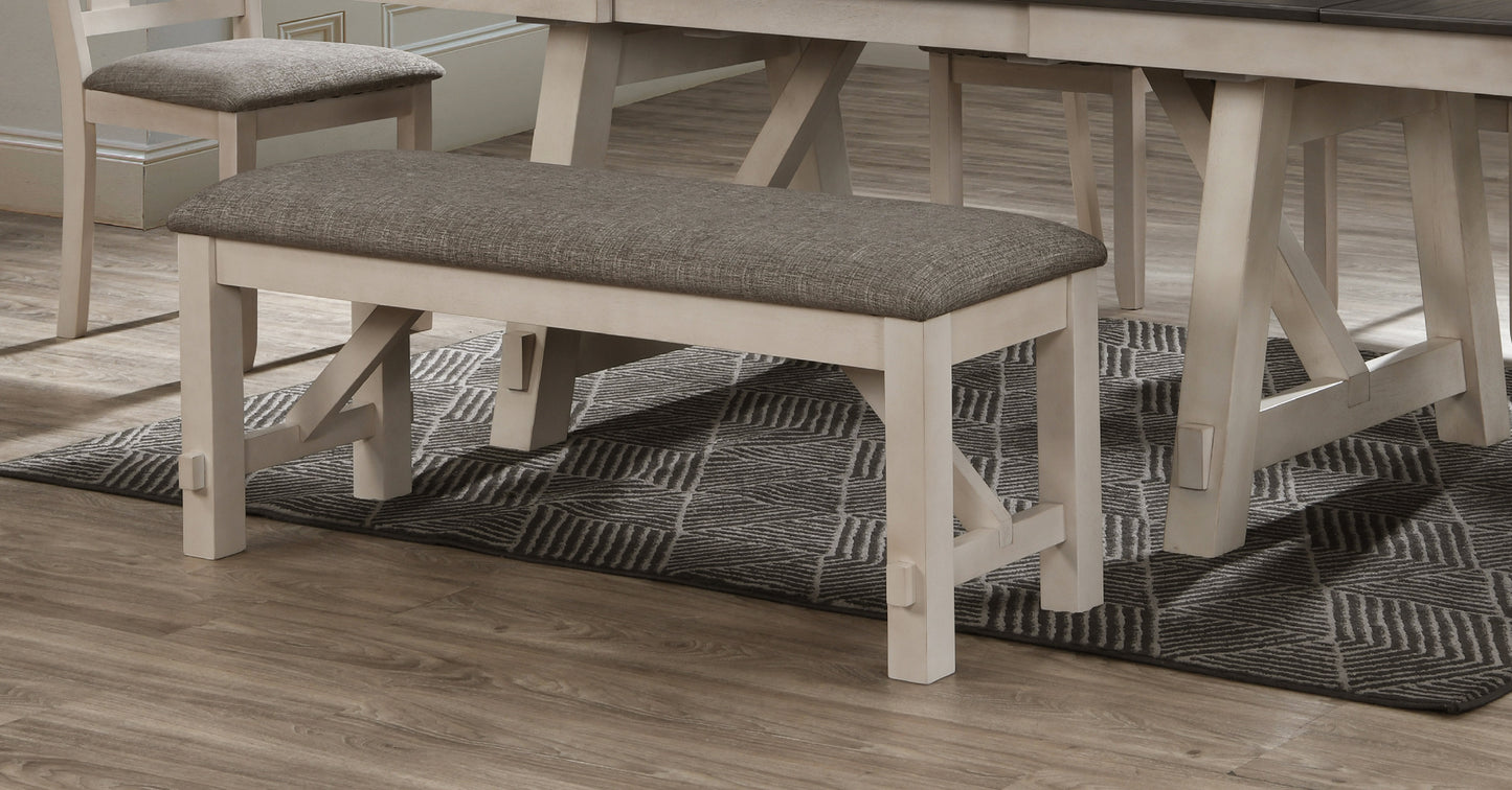 Gray upholstered dining bench with light wood frame and crisscross leg accents