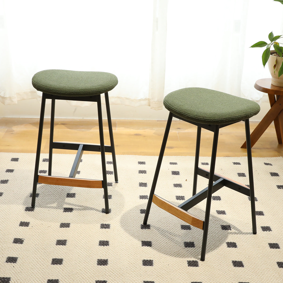 Green upholstered bar stool with black metal legs and wooden accents