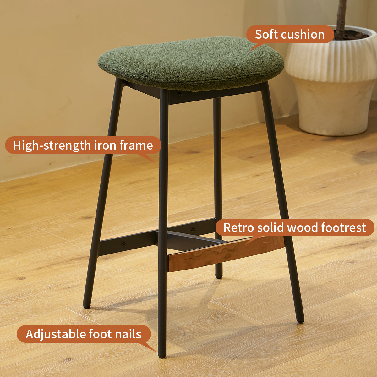 Green cushioned stool with black iron frame and wood footrest