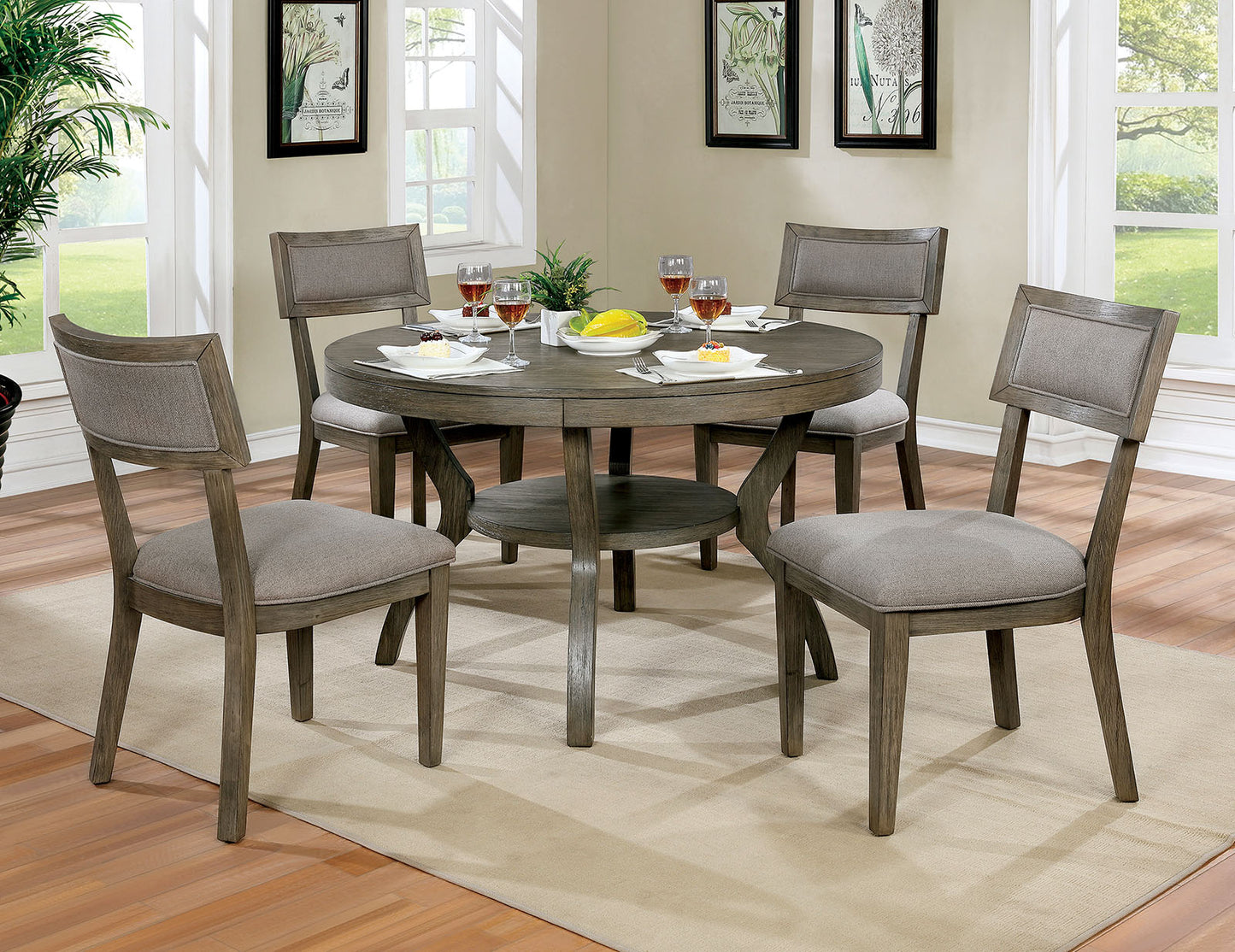 Round gray washed wood dining table with four upholstered chairs