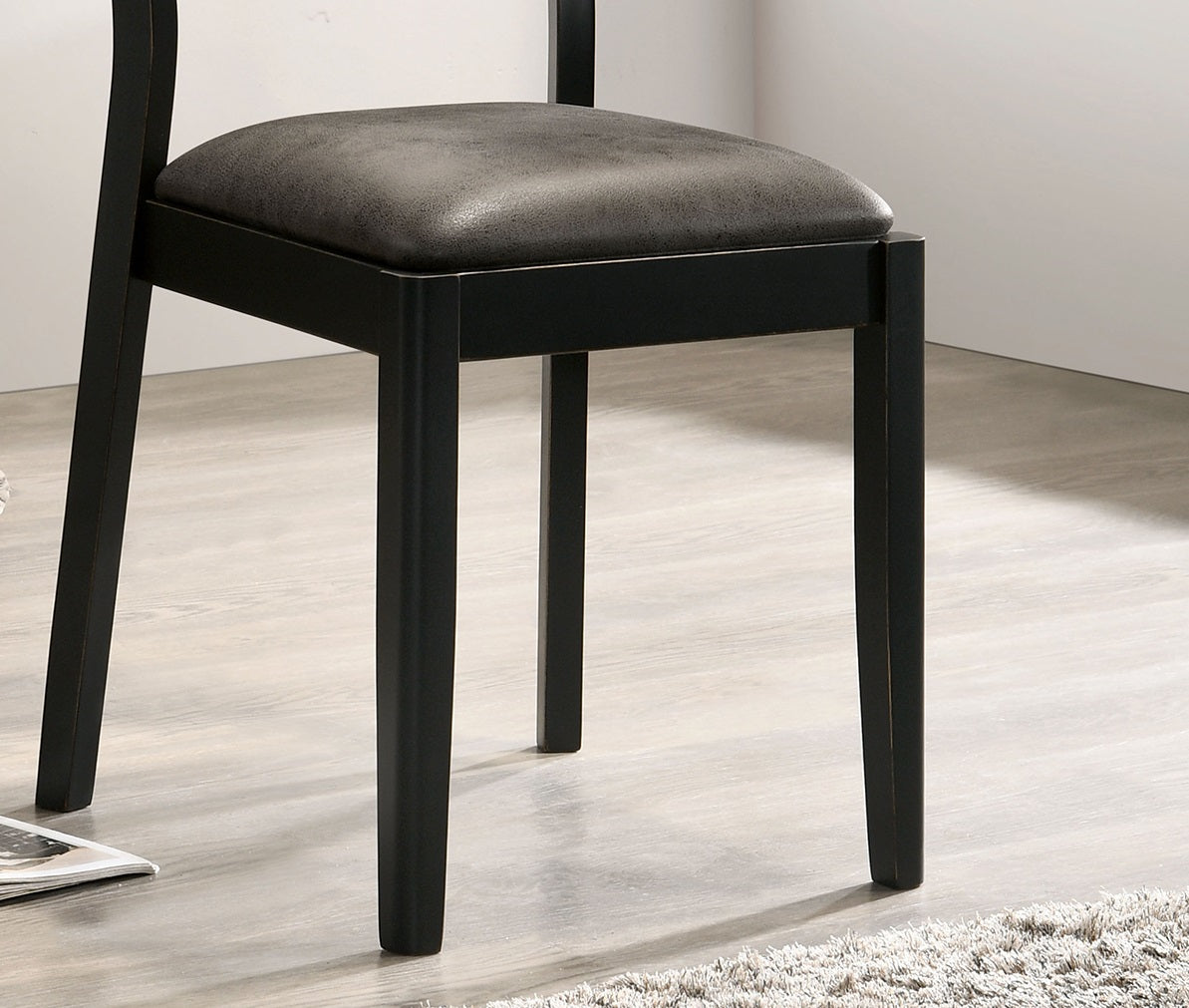 Black wooden dining chair with textured grey seat cushion