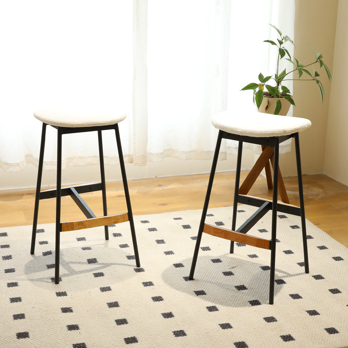 Modern counter stool with white cushioned seat and black metal legs