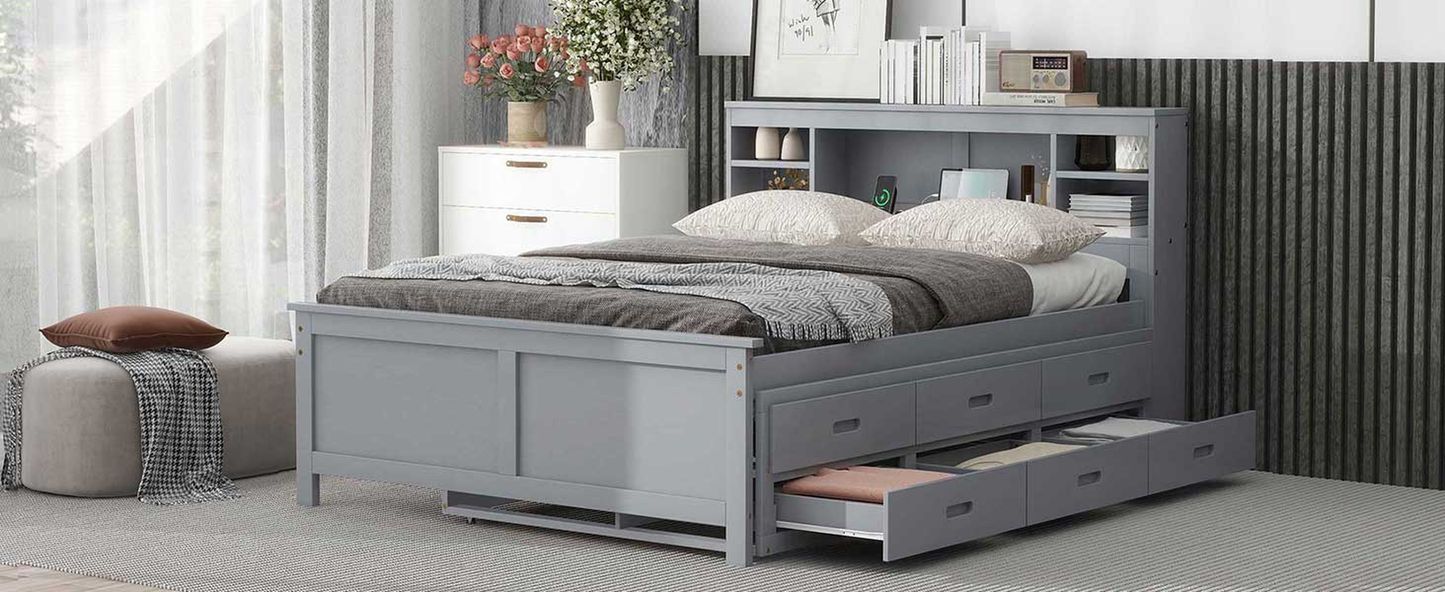 Gray wooden captains bed with multiple storage drawers and builtin headboard shelves