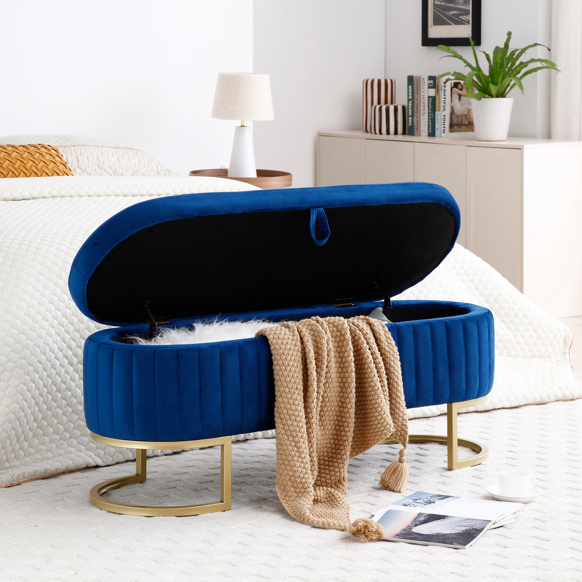 Royal blue velvet storage ottoman with gold base and open lid