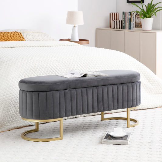 Grey velvet storage ottoman with gold metal legs and channel tufting
