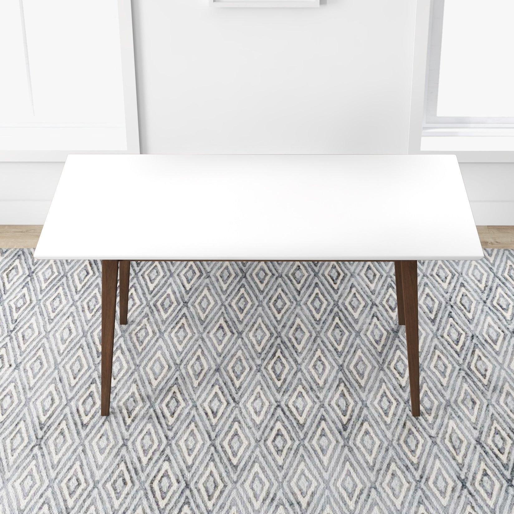 White rectangular dining table with dark wood legs on a geometric diamond rug