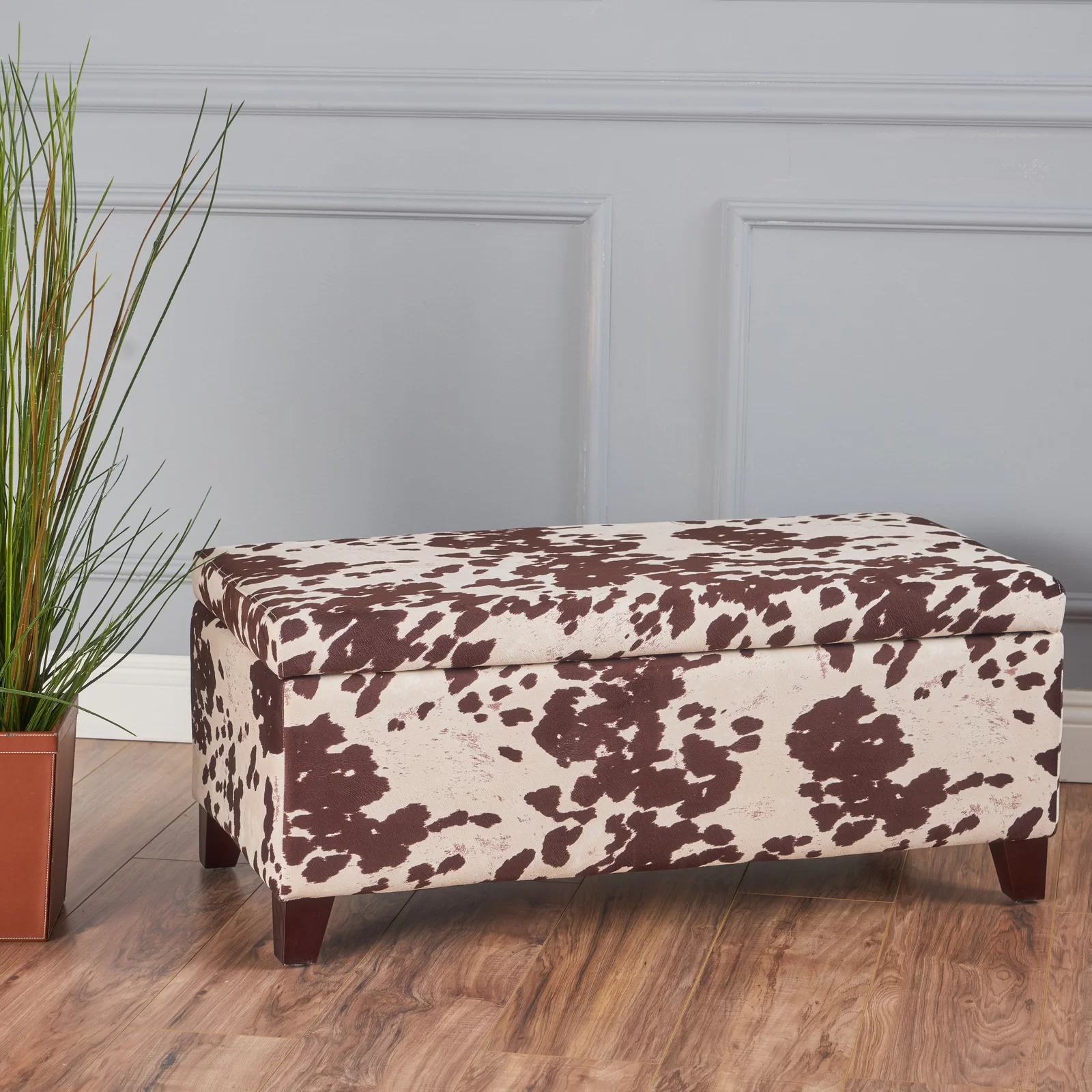 Brown and cream cow print storage ottoman with wooden legs
