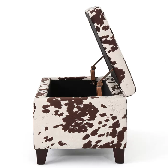 Brown and white cowhide storage ottoman with lid open