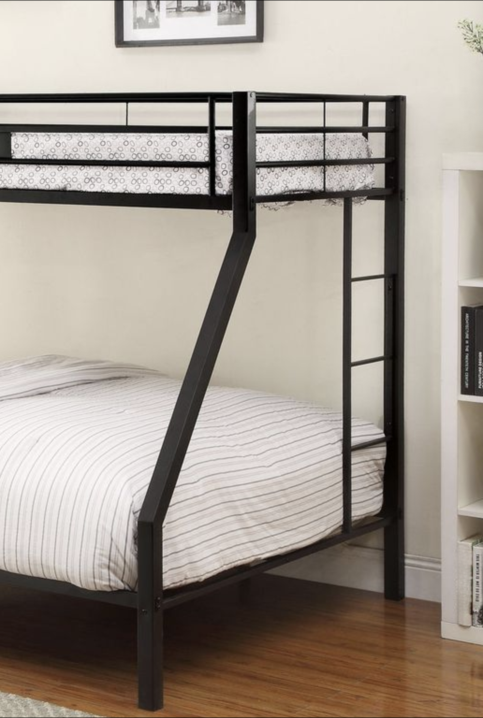 Black metal triple bunk bed with white striped bedding