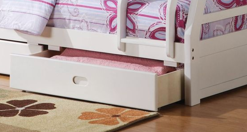 White wooden trundle drawer with pink bedding