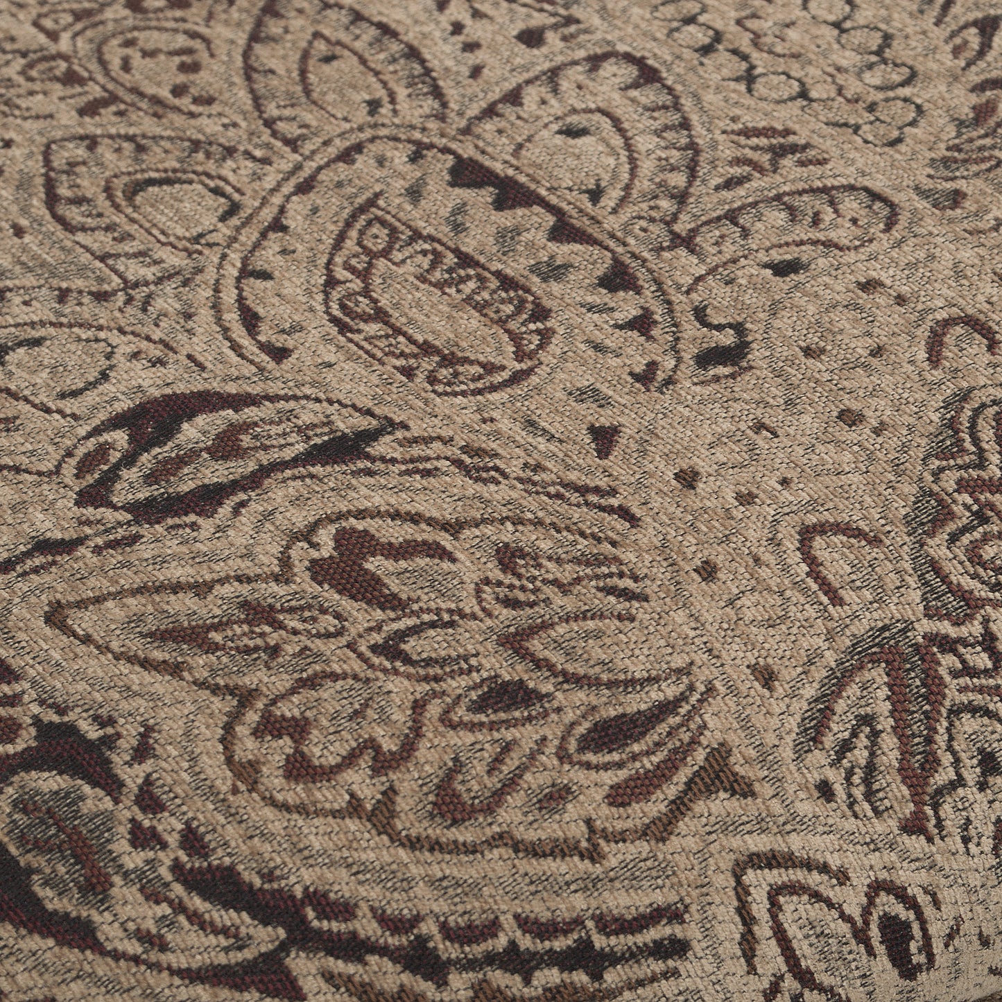 Closeup of beige fabric with a detailed damask pattern in brown