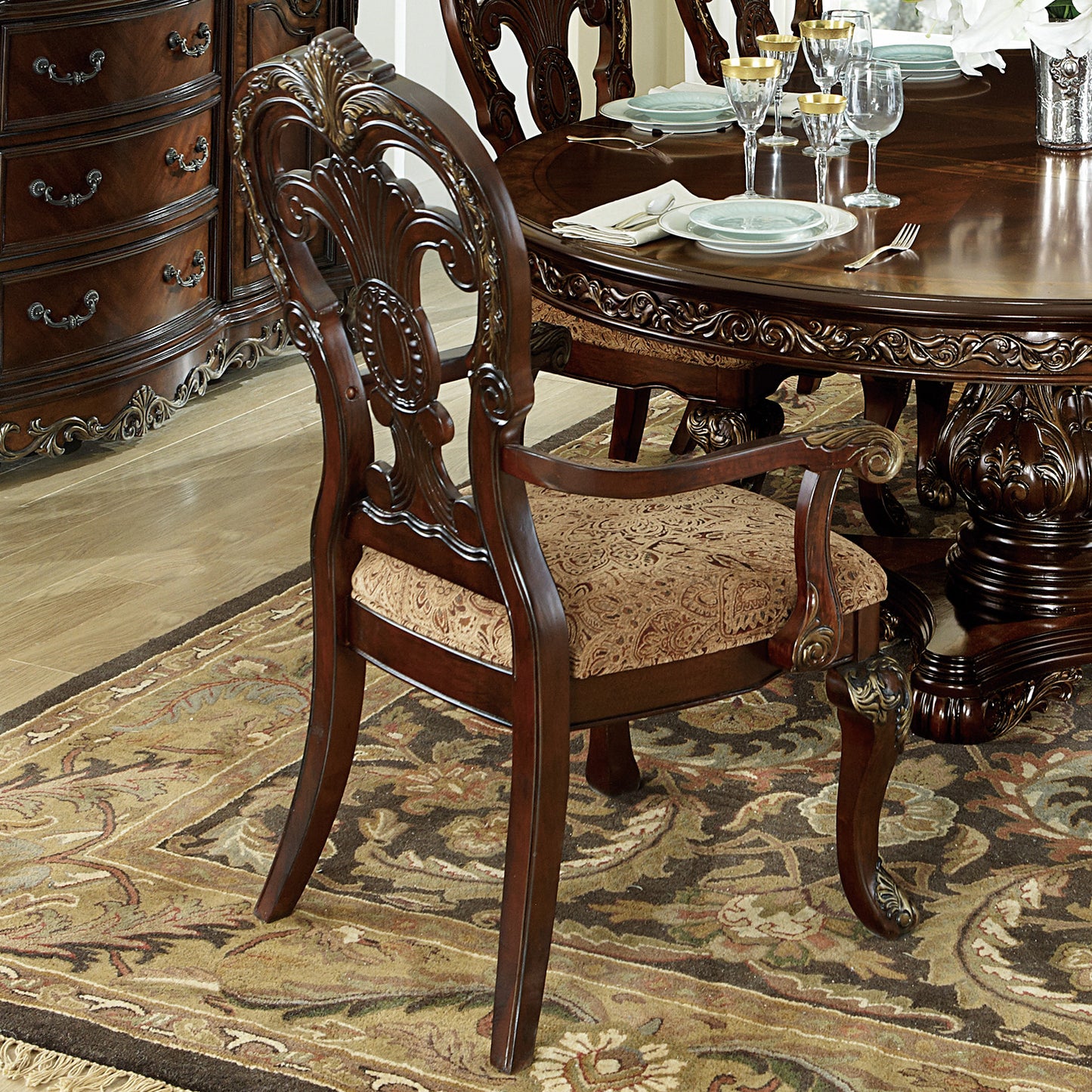 Ornate mahogany dining chair with detailed carving and upholstered seat