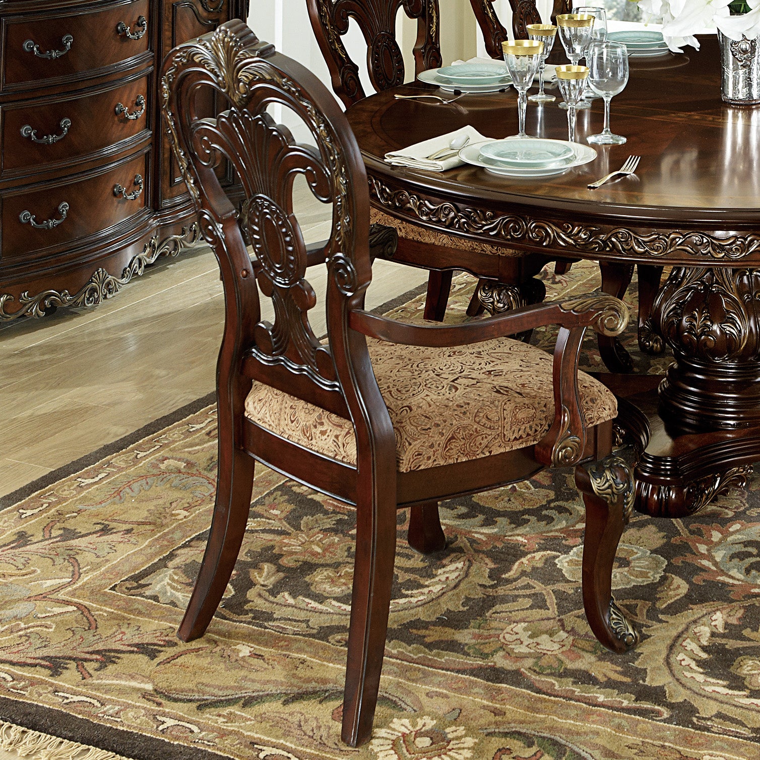 Ornate mahogany dining chair with detailed carving and upholstered seat