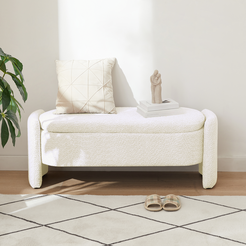 Cream boucle storage bench with plush pillow and decorative statue
