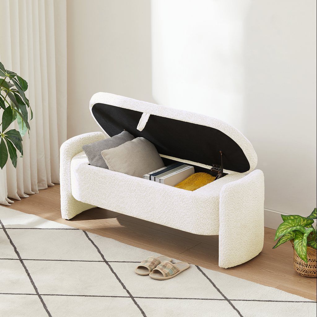 White boucle storage bench with open lid revealing pillows and books