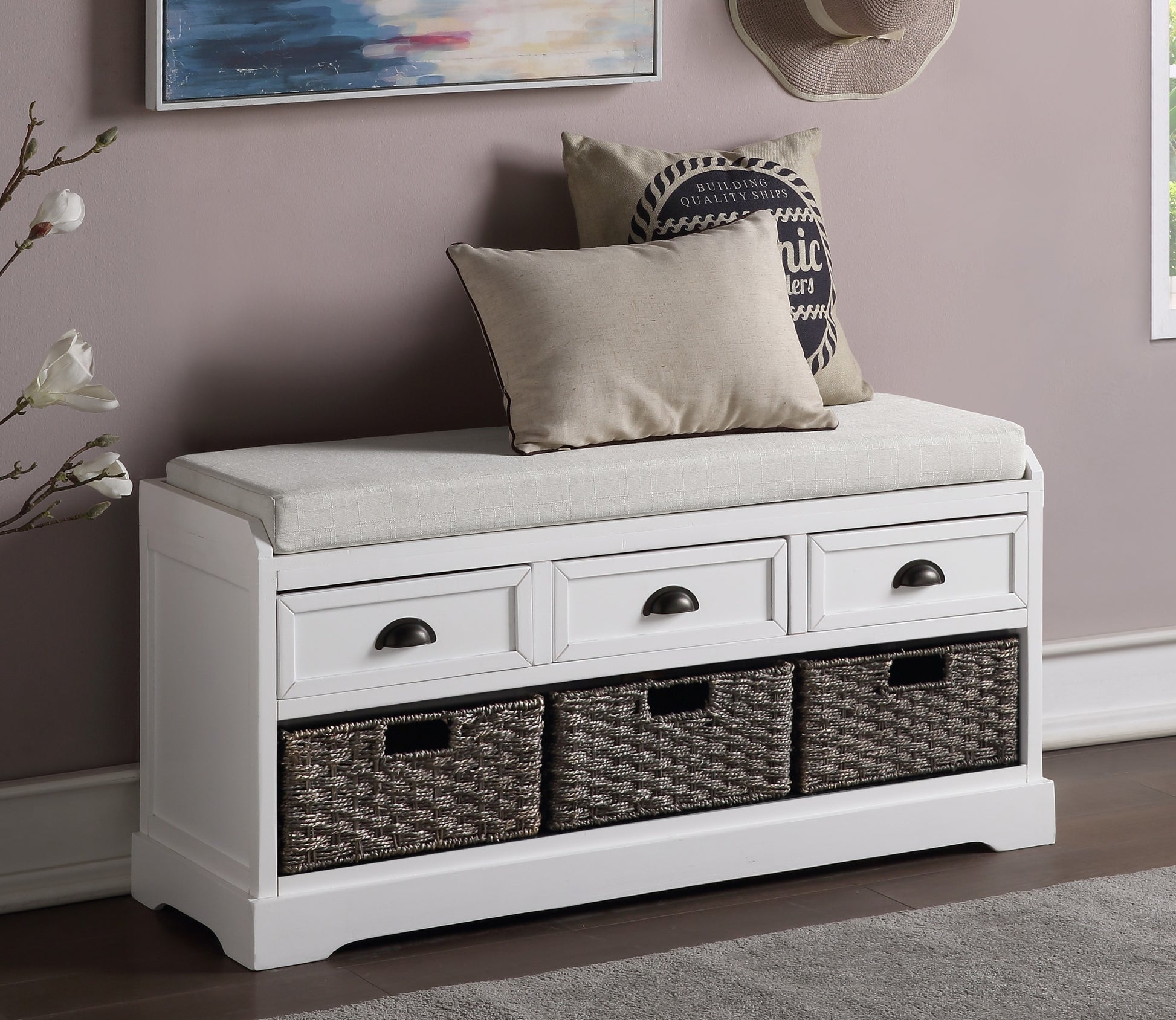 White entryway bench with upholstered seat and woven storage baskets