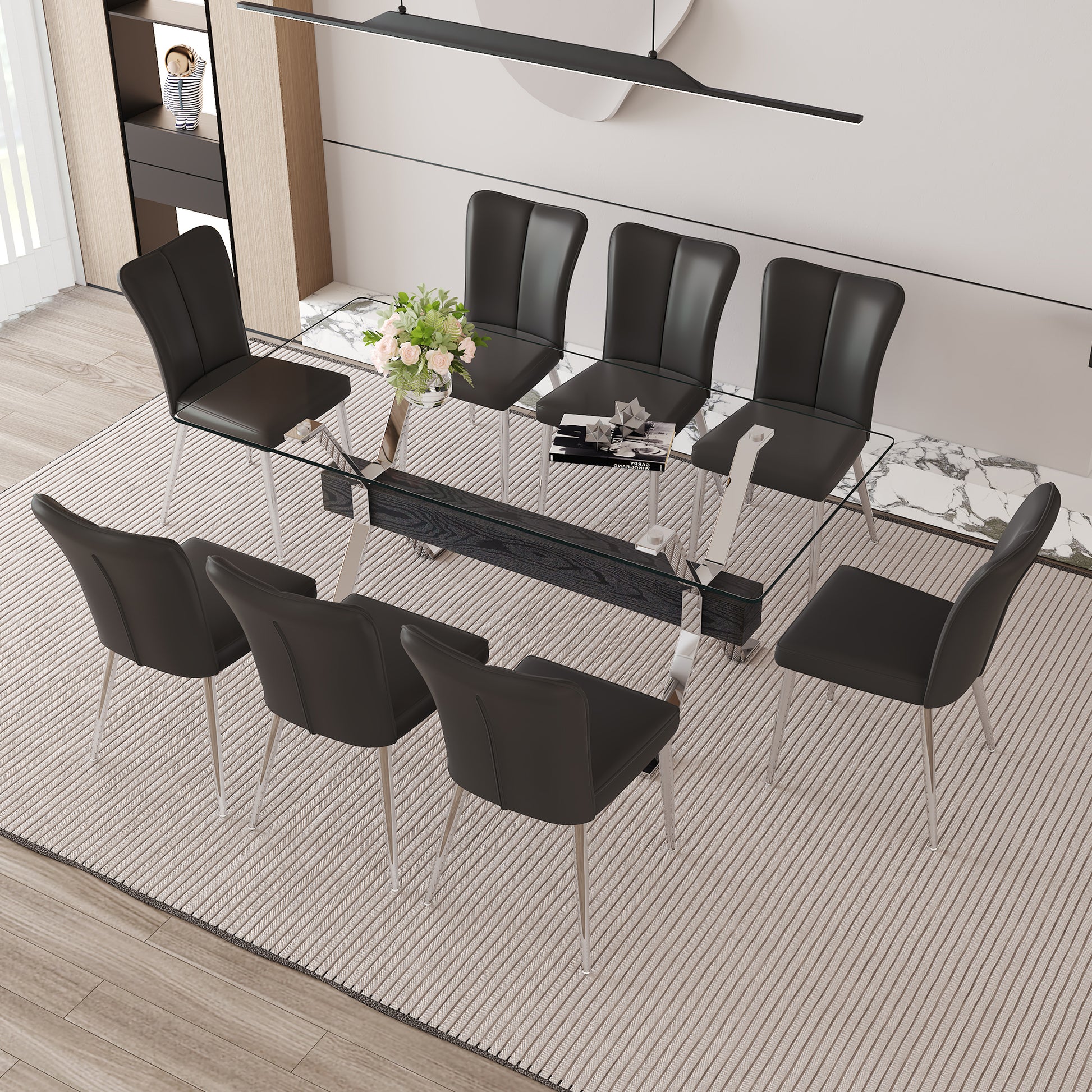 Modern glass dining table with eight black leather chairs and chrome legs