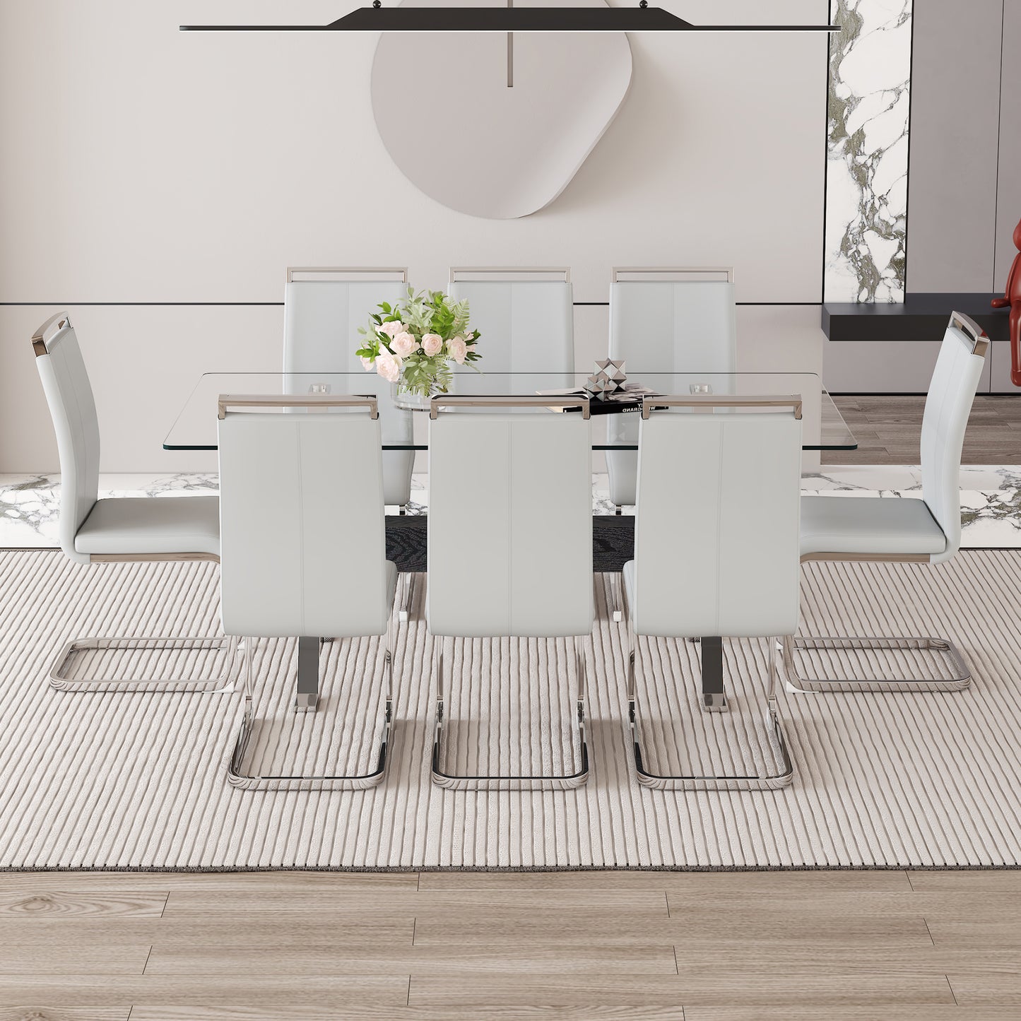 Modern white leather dining chairs with chrome frames surrounding a glasstop table