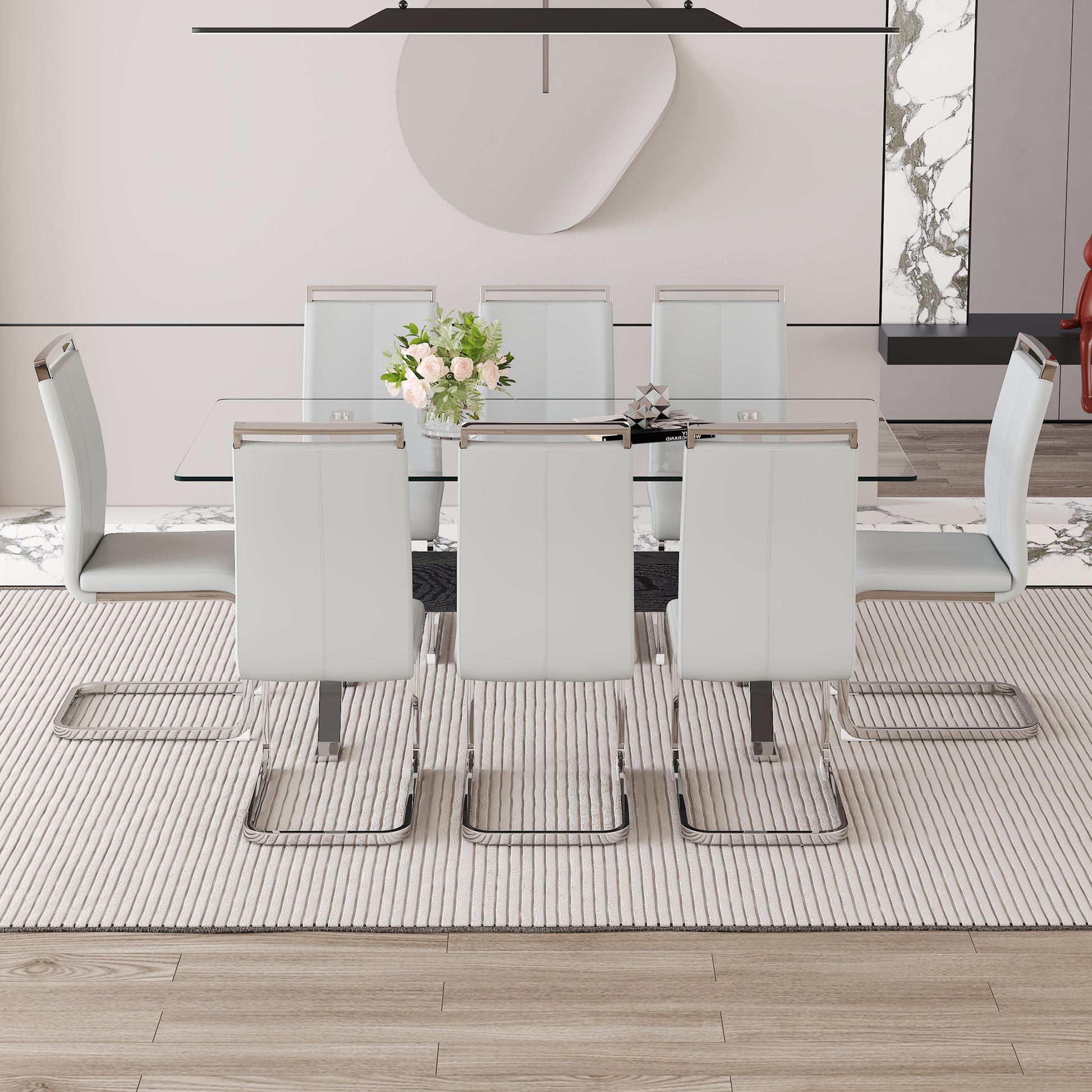 Modern white leather dining chairs with chrome frames surrounding a glasstop table