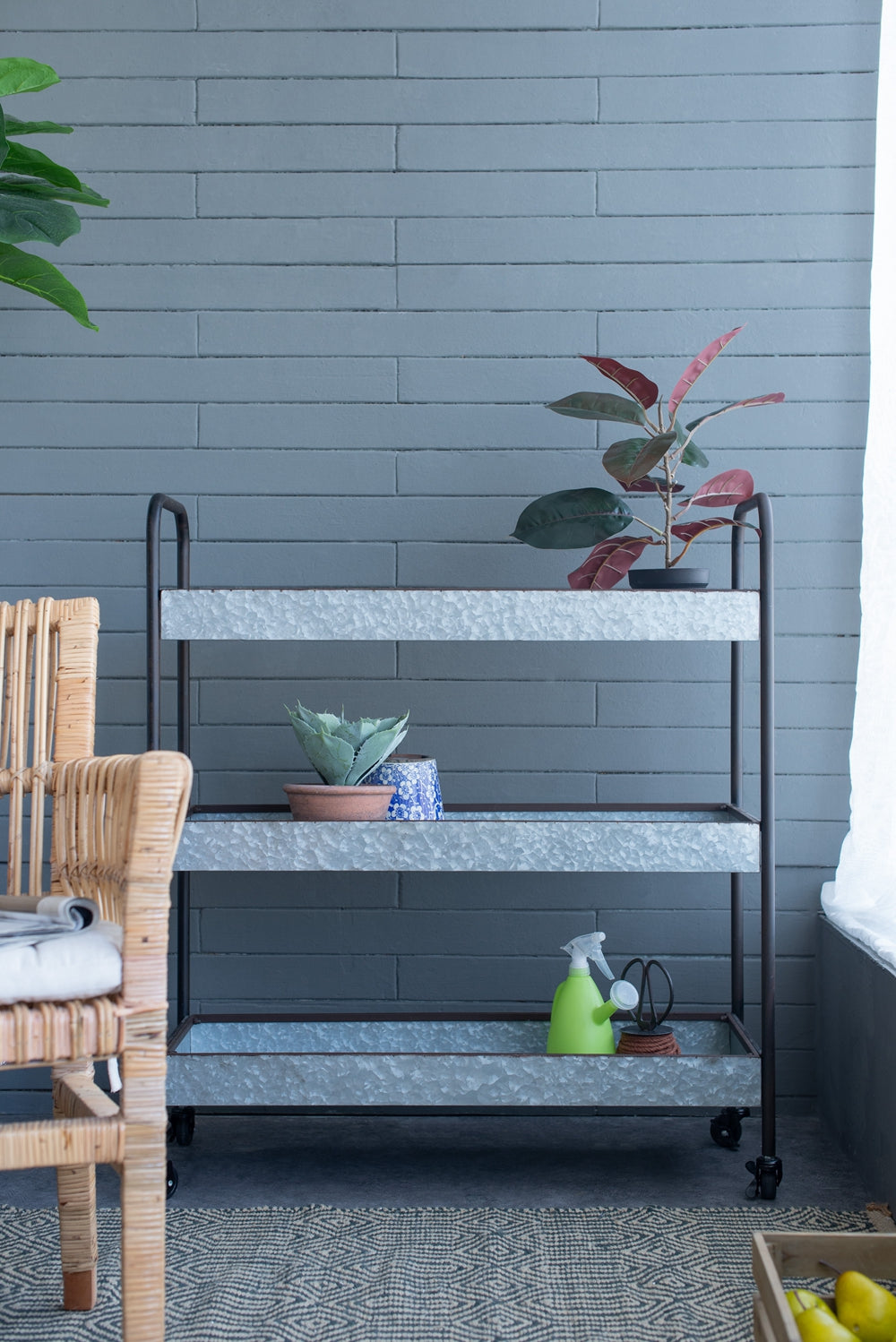 Galvanized metal threetier rolling cart with plants and gardening tools