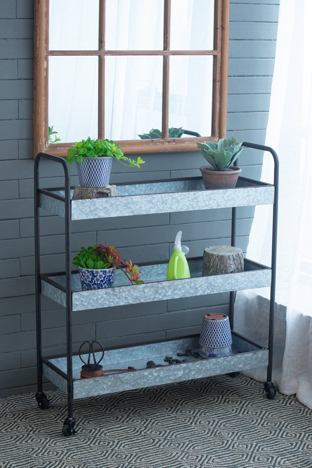 Galvanized metal tiered cart with plants and decorative items