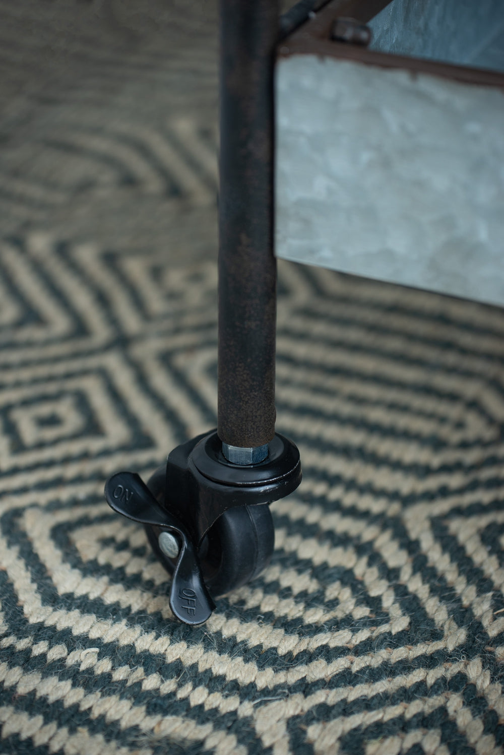 Black locking caster wheel with ONOFF lever on industrial cart leg