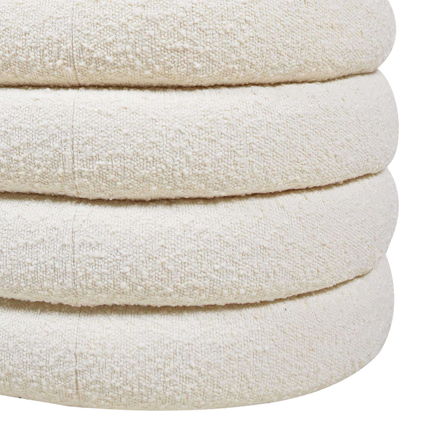 Closeup view of a textured creamcolored round ottoman stacked