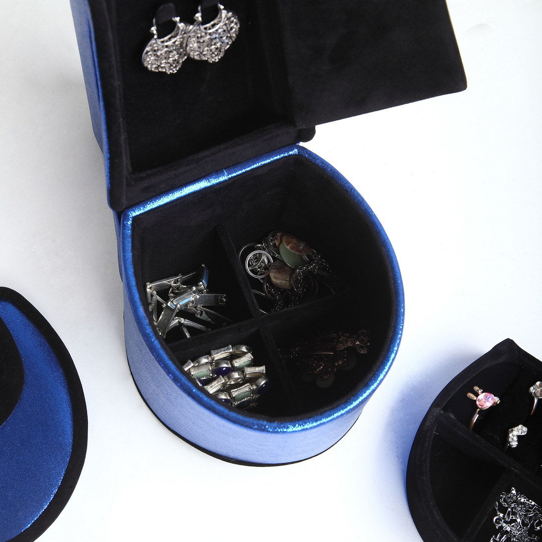 Open blue velvet jewelry box with assorted silver earrings and rings displayed