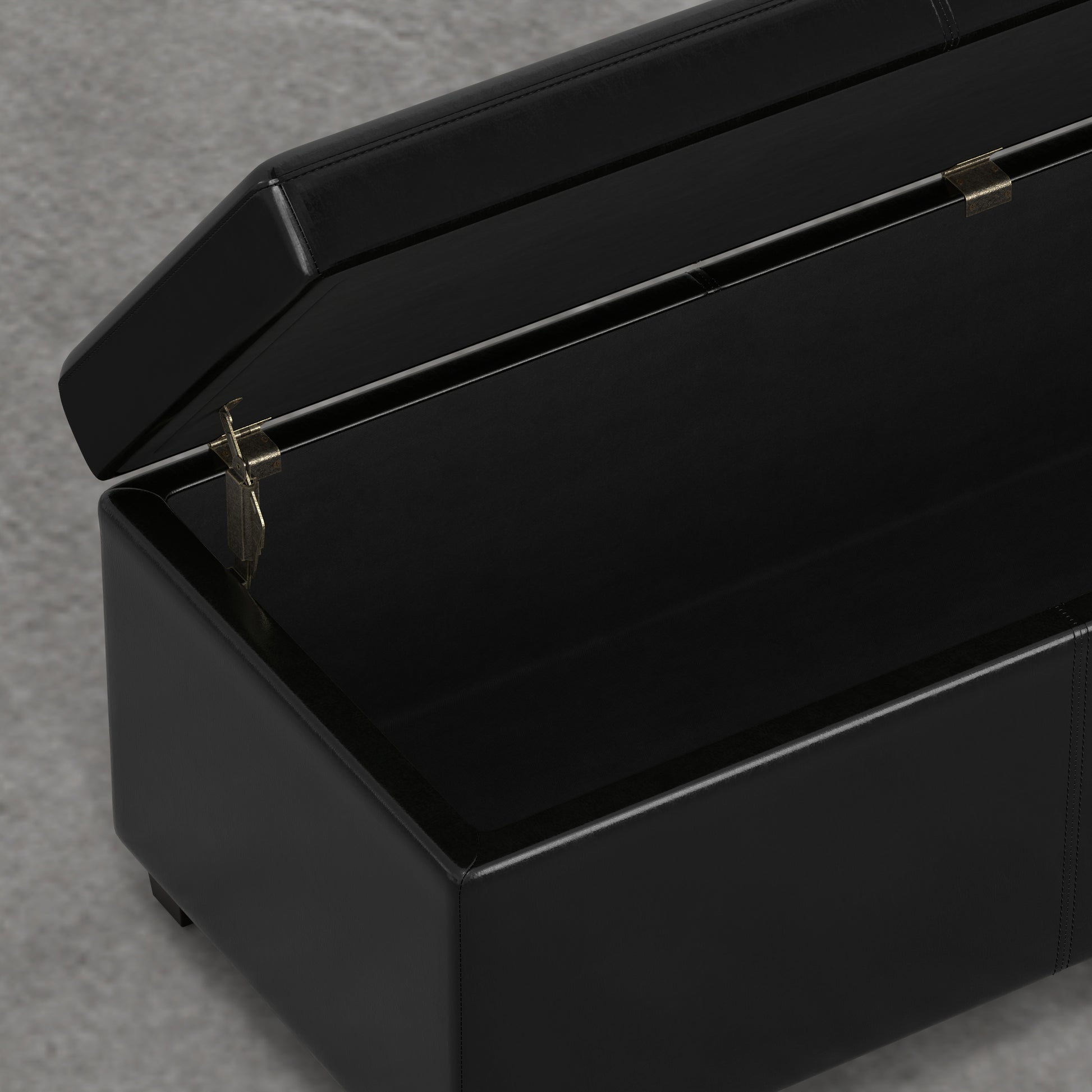 Black faux leather storage ottoman with hinged lid open