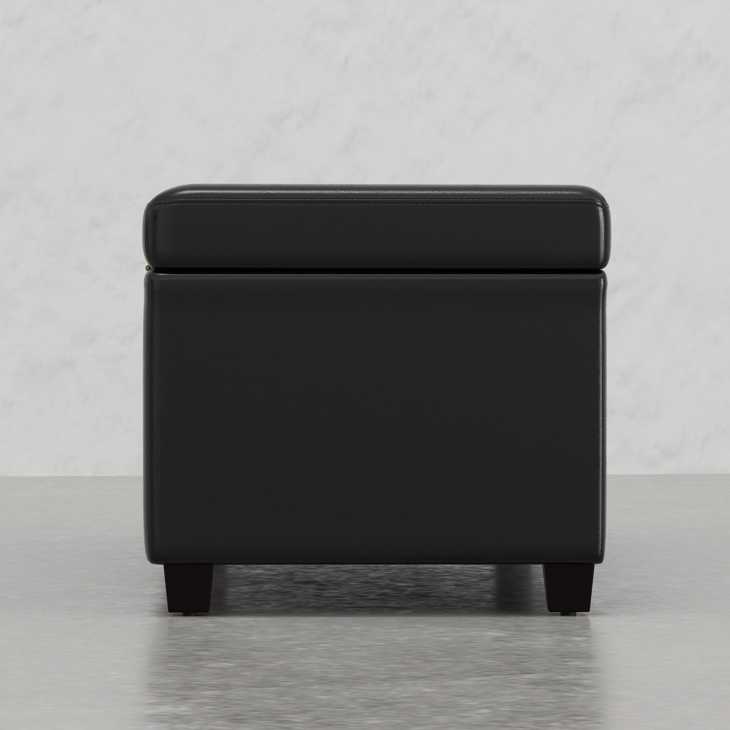 Black faux leather storage ottoman with tufted lid and dark wood legs