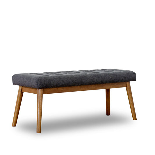 Dark gray upholstered bench with tufted seat and tapered wooden legs