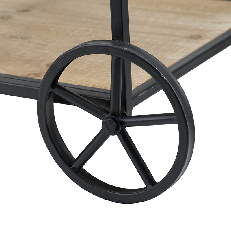 Black metal wheel on a rustic wooden serving cart